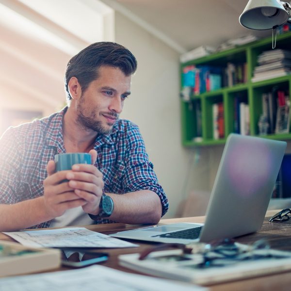 Man drinking coffee at computer