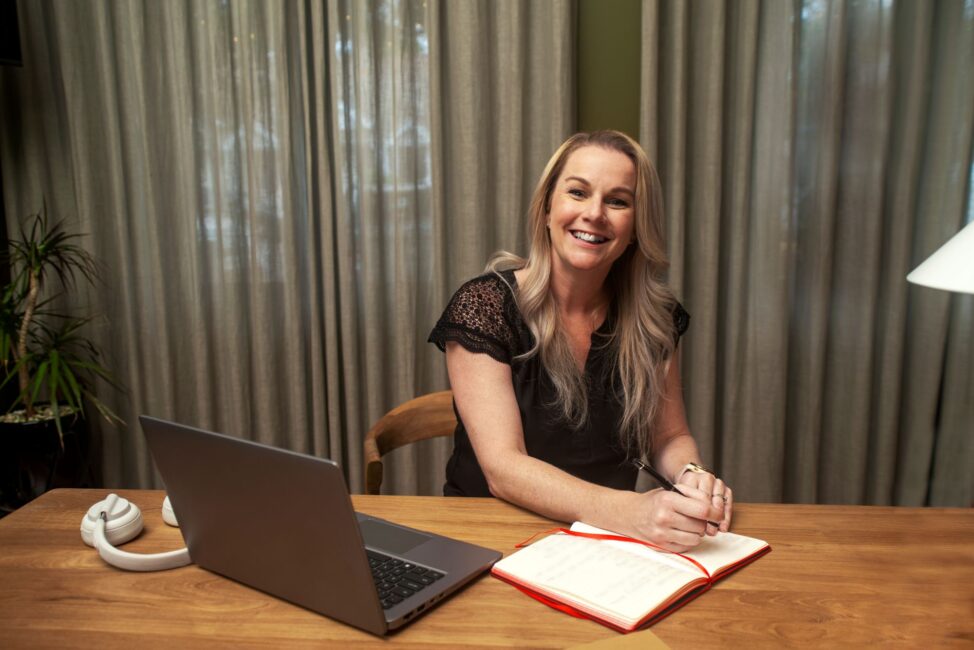 Western Sydney Online student studying online and writing in a red notebook